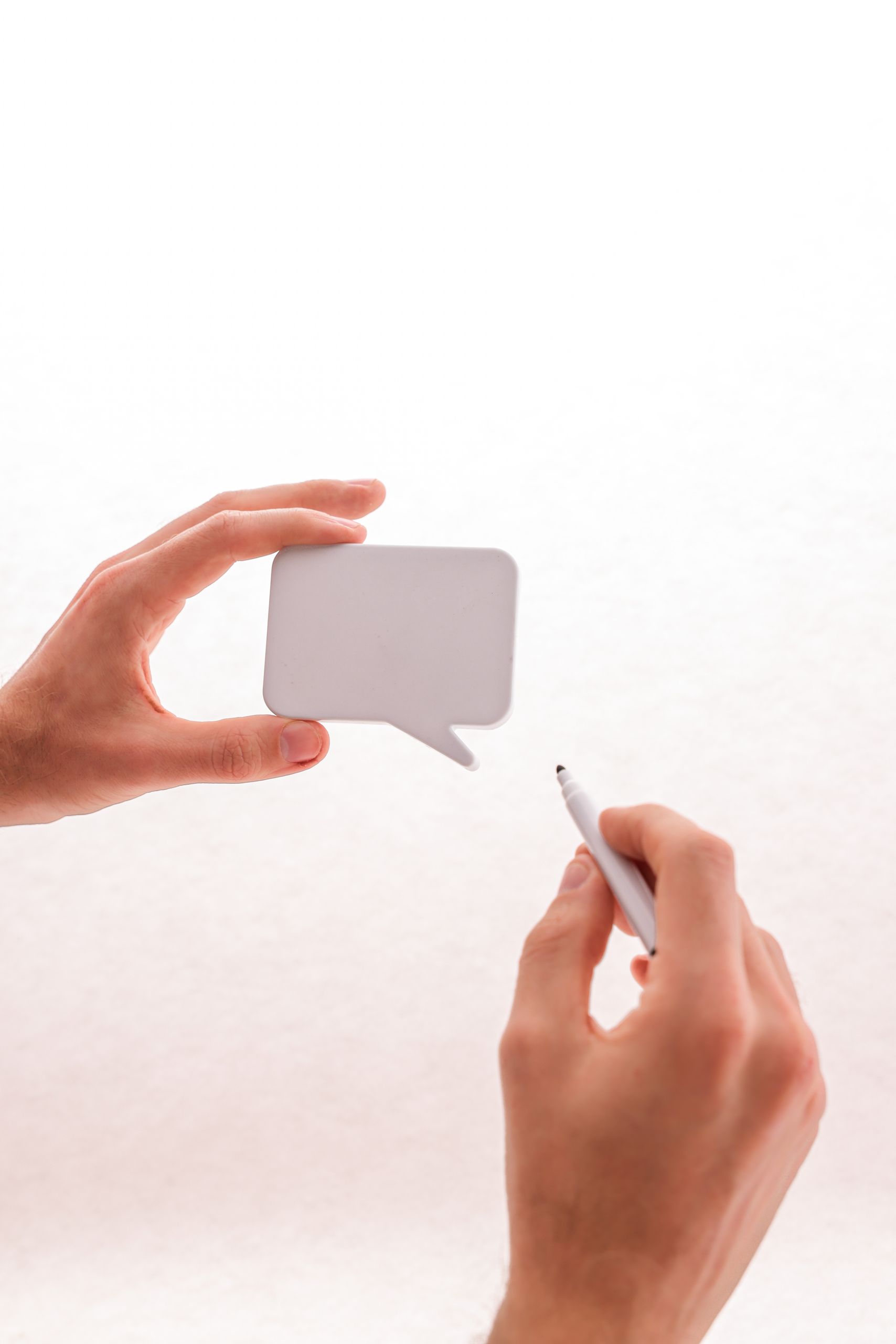 Mains tenant une bulle de dialogue et un stylo